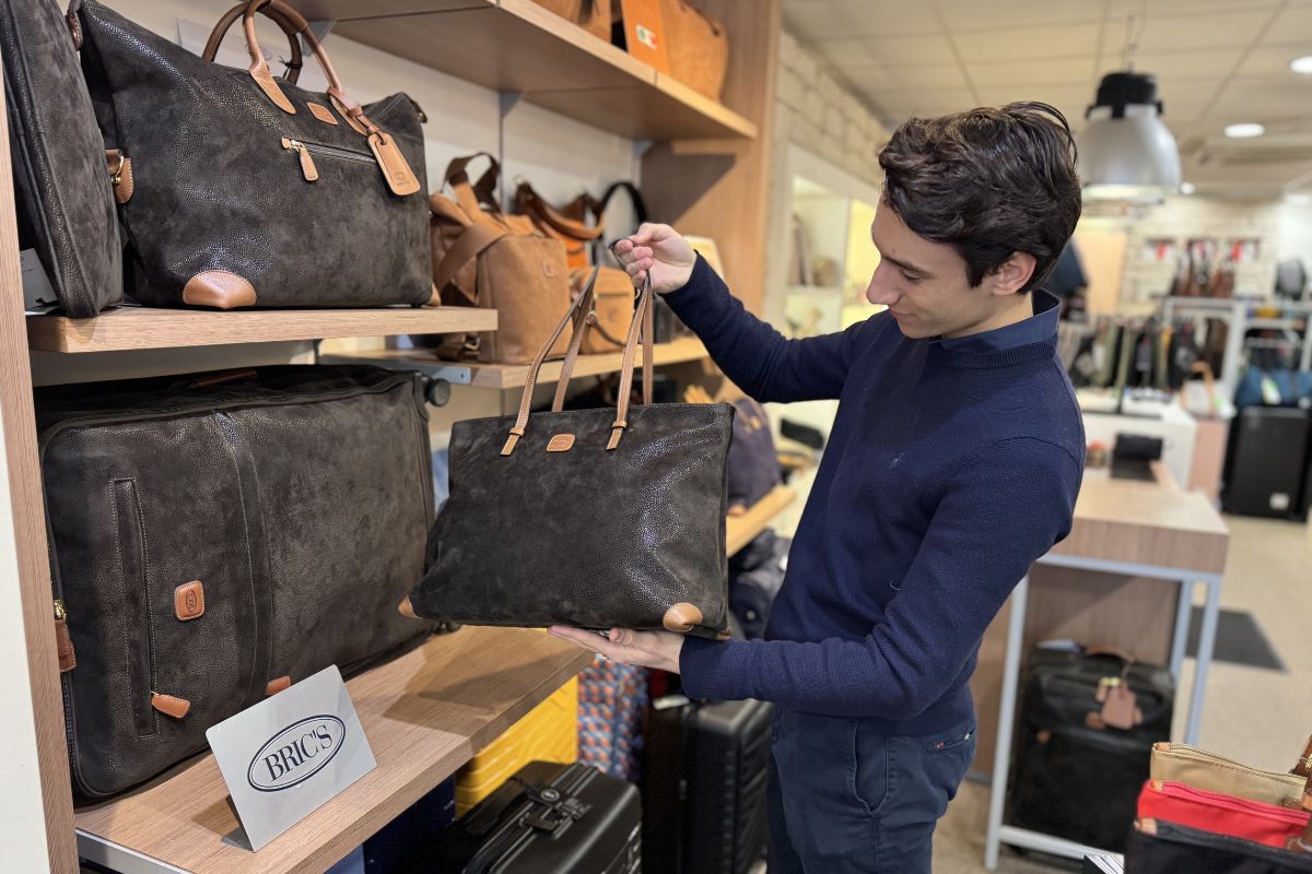 In de winkel met personeel die uitleg geeft over een Brics tas