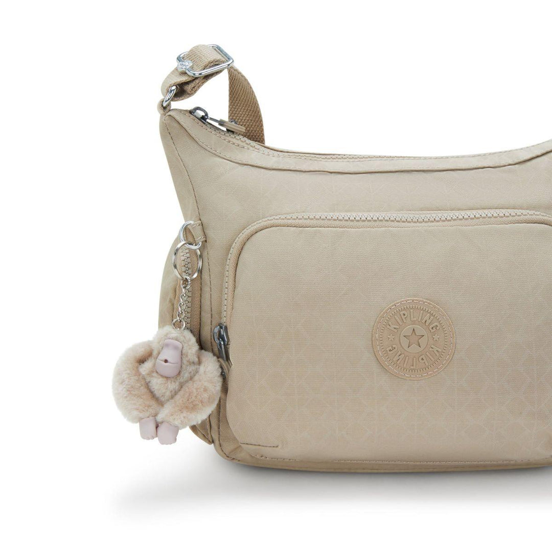 Details van de voorkant van de Kipling Gabb schoudertas in Signature-Beige #kleur_signature-beige