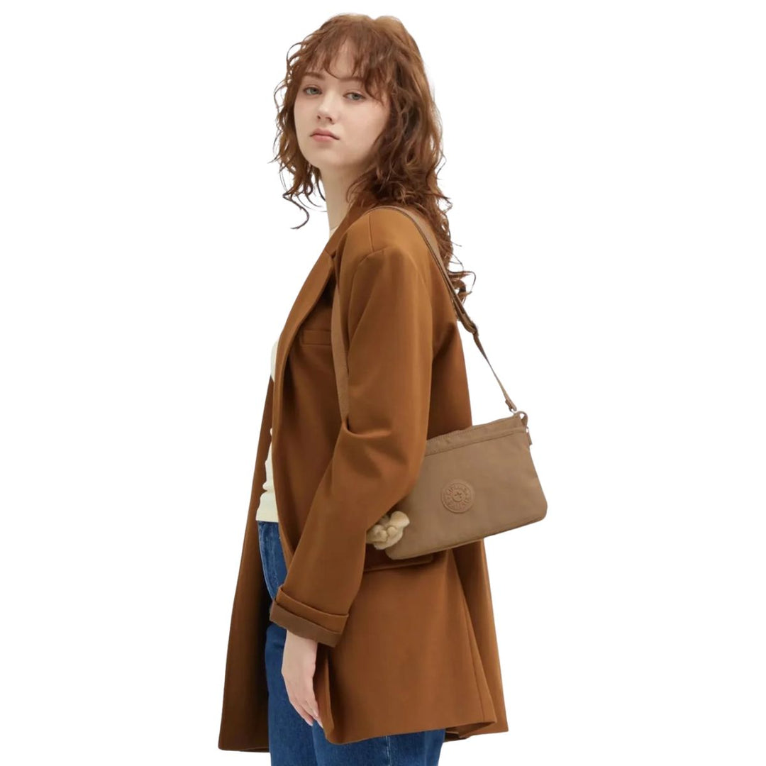 De Kipling RIRI Crossover tas early-tan met een model #kleur_early-tan